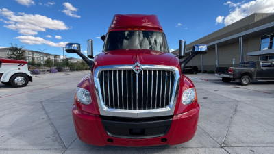 Truck front view showing red International LT625 grille and headlights