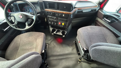 Interior of a 2022 International LT625 truck cab showing steering wheel, dashboard, and front seats with center console and instrument panel.