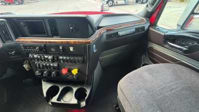Interior dashboard of a 2022 International LT625 truck showing steering wheel, center console with controls, vents, wood trim, and cup holders.