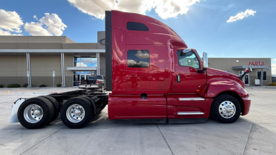 Side view of a red 2022 International LT625 tractor-trailer cab showing the sleeper with chrome dual rear axles and windows.