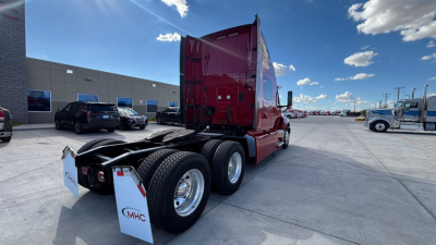 Tractor truck rear view showing red International LT625 sleeper cab and dual rear axles with chrome wheels.