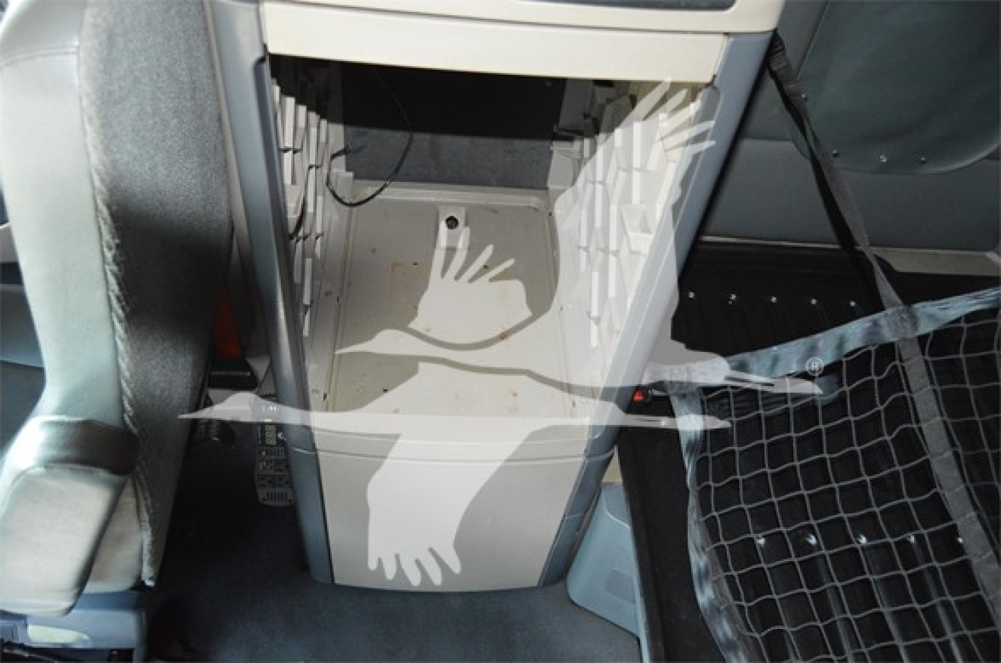 Truck cab interior center console area of a 2014 Freightliner Cascadia 125 Evolution showing footwell and seating area.