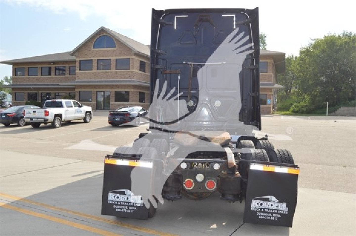 Freightliner Cascadia 125 Evolution rear view showing chassis and fifth-wheel, with stock numbers and dealership branding on mud flaps.