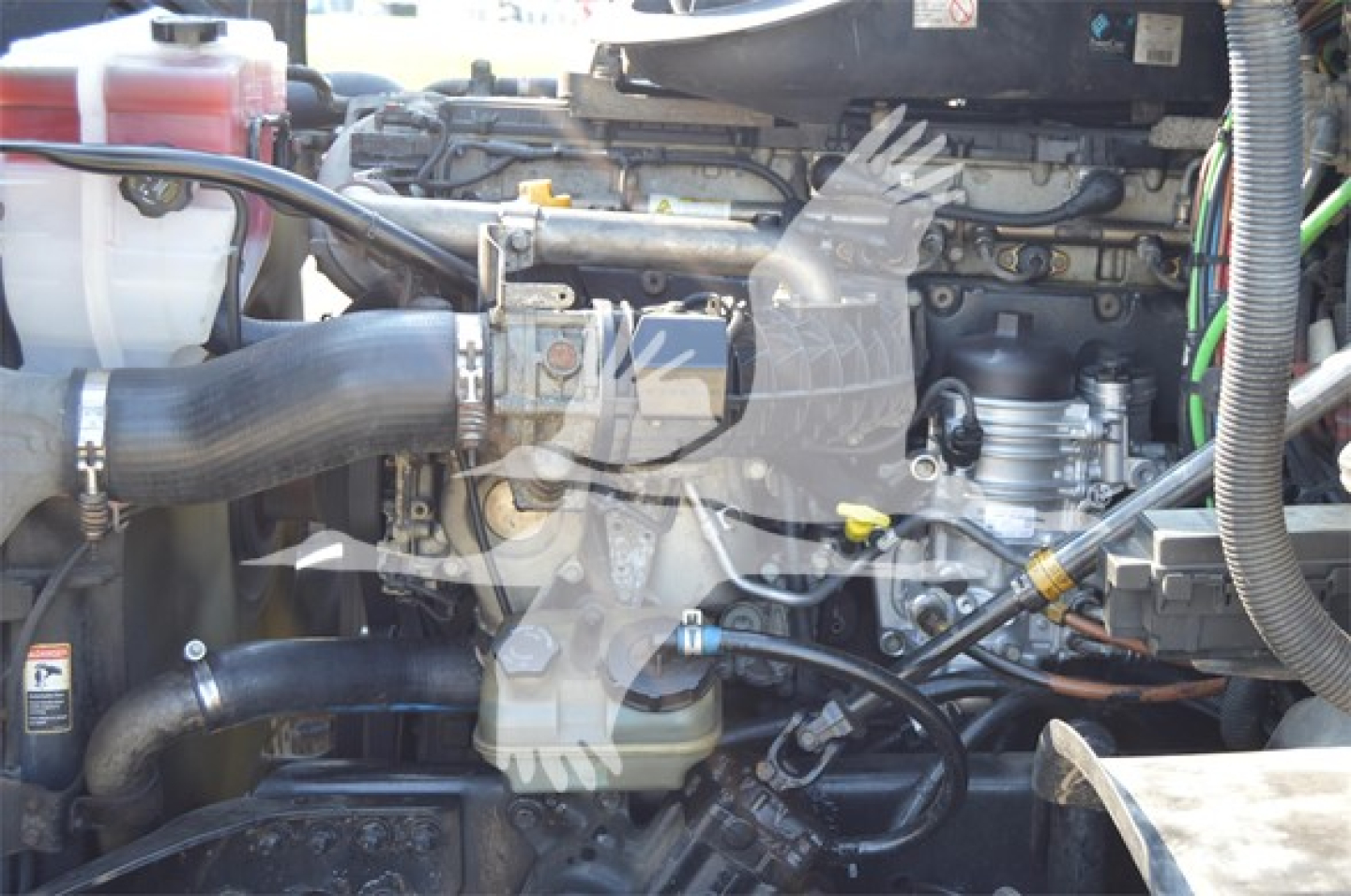Truck engine bay with hoses and components visible in a Freightliner Cascadia Evolution engine compartment.