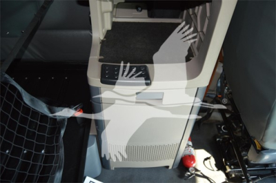 Cabin area of a Freightliner Cascadia 125 Evolution interior, center console with steps and storage, partial floor mat, interior trim visible.