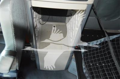 Truck cab interior center console area of a 2014 Freightliner Cascadia 125 Evolution showing footwell and seating area.