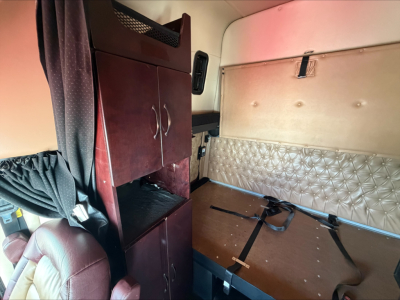 Western Star 4900 truck cab interior sleeper area with storage cabinet and quilted side wall panel.