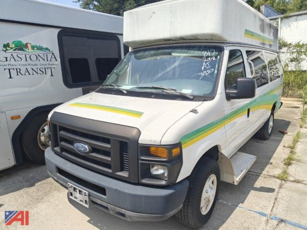 Ford E-Series van shown in a used condition with a raised rooftop cap and green-yellow stripes along the side. Front grille with Ford emblem, windshield with handwritten numbers.
