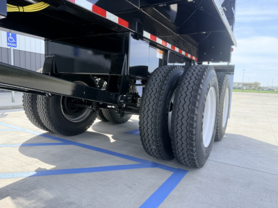 Armor Lite SHD dump trailer 28/48 1/4 frame in-service showing dual rear axles and black painted steel frame with tires and wheel rims.