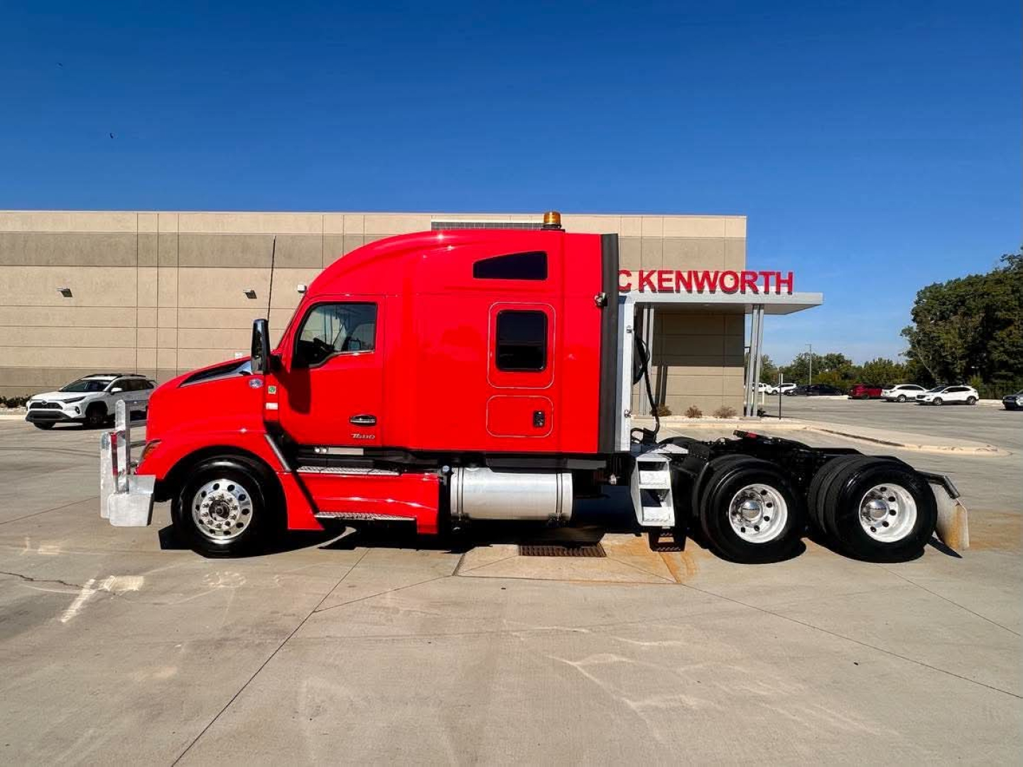 Kenworth T680 conventional sleeper tractor in red, side view showing cab and dual rear axles.