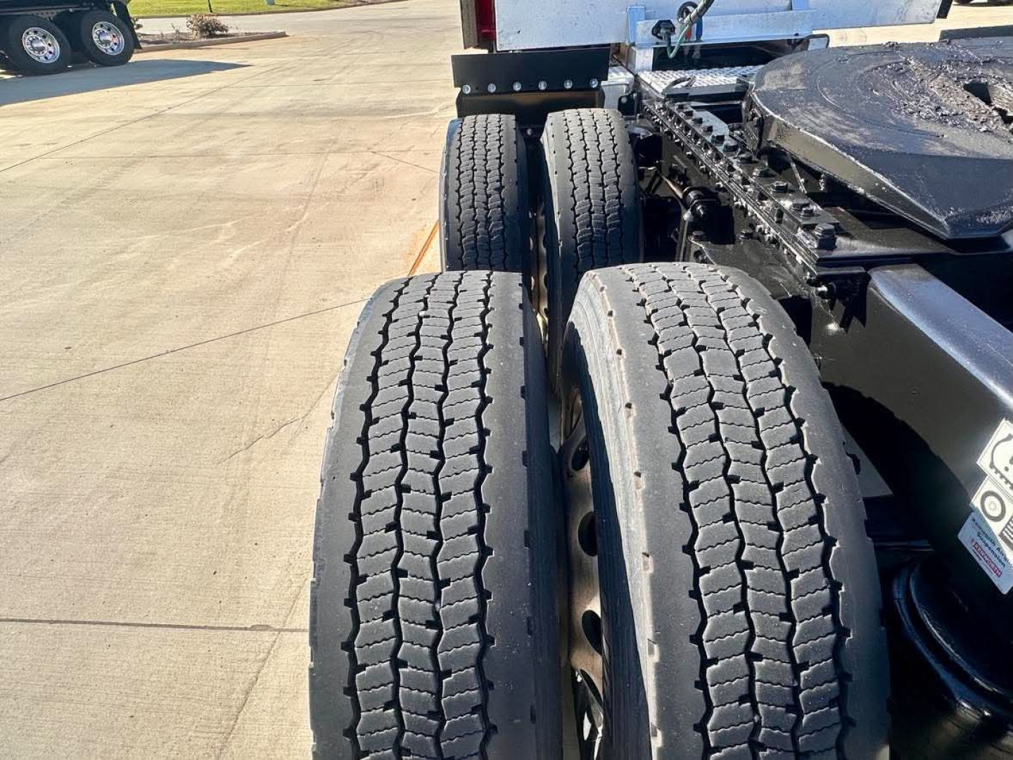 Kenworth T680 truck rear dual tires and chassis view showing tandem axle and wheel rims.