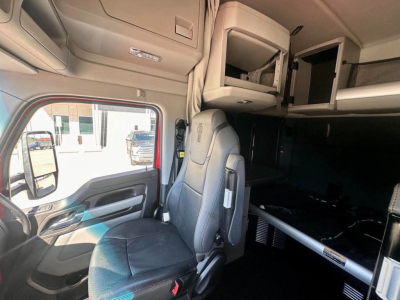 Kenworth T680 cab interior showing driver seat and overhead storage compartments.
