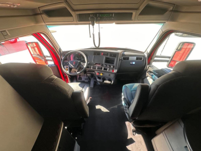 Kenworth T680 truck cabin interior showing steering wheel, dashboard, and two front seats with center console and overhead panels.