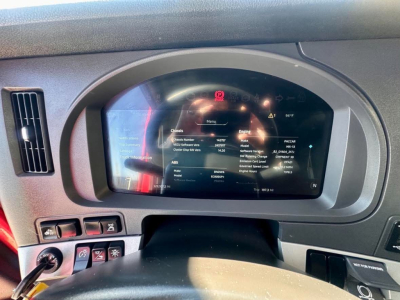 Dashboard display of a 2023 Kenworth T680 showing multi-information screen with vehicle data and warning icons inside the instrument cluster.