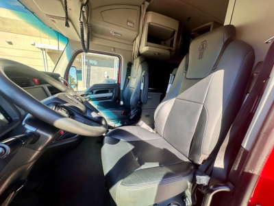 Kenworth T680 truck cab interior showing driver's seat and passenger seat with dashboard, steering wheel, and overhead sleeper area.