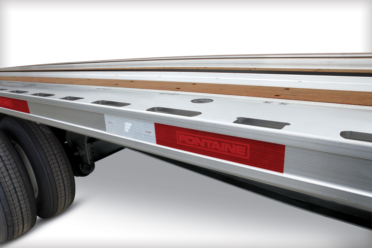 Fontaine 53' combo flatbed trailer side rail with red reflected panel and branding, dual rear axle area visible.