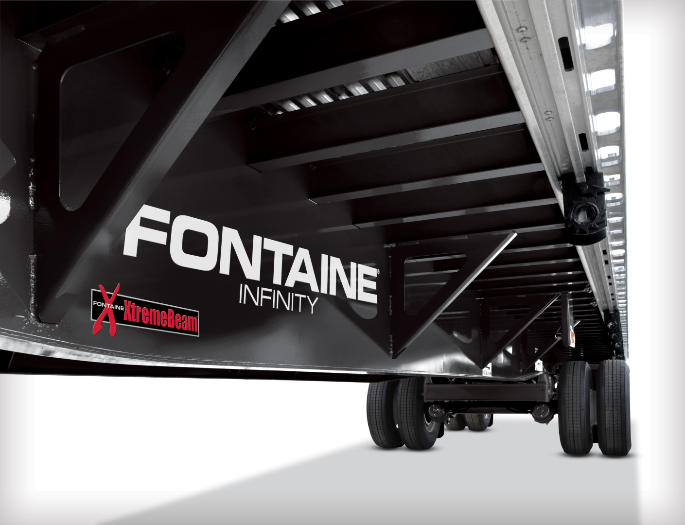 Fontaine Infinity trailer side with large 'FONTAINE' logo, 'XTremeBeam' sticker, and stabilizing wheels visible under the flatbed section.
