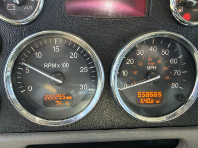 Peterbilt 389 dashboard showing two round gauges: left tachometer RPM x100 and metric hours; right mph speedometer with odometer 558,665 miles and 640.8 mi trip.