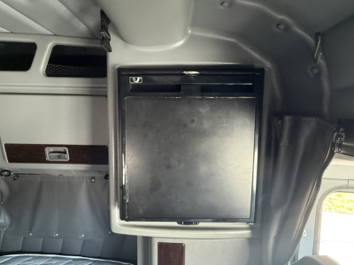 Peterbilt 389 cab interior with a small black refrigerator door mounted in sleeper area.