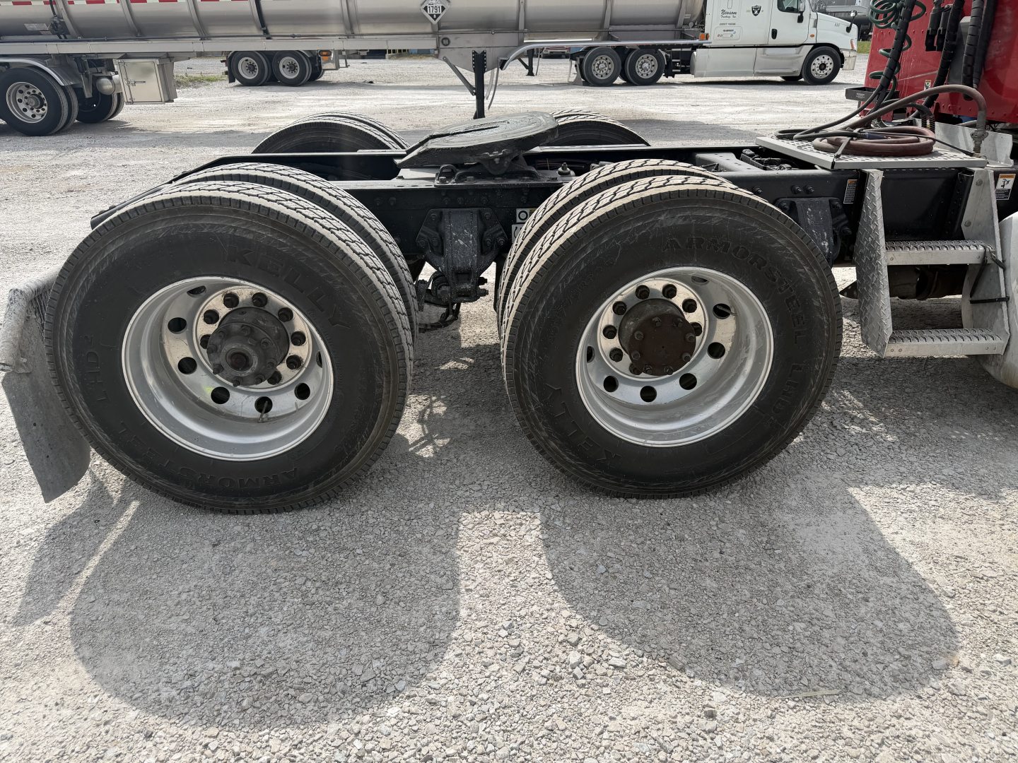 Dual rear wheel assembly of a Peterbilt truck showing two axles and tires.