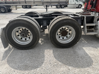 Dual rear wheel assembly of a Peterbilt truck showing two axles and tires.