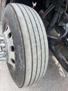 Dual front wheel/truck axle of a 2017 Peterbilt 579 with visible tire tread and wheel hub.