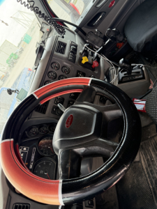 Peterbilt 579 truck interior showing steering wheel and dashboard with gauges and switches.