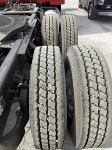 Peterbilt 579 truck chassis showing rear duals with treaded tires and visible suspension components.