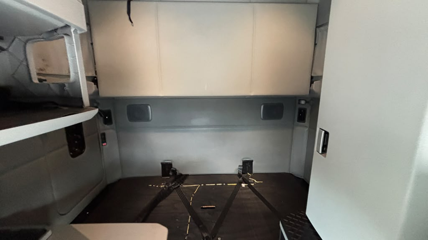 Kenworth T680 cab interior cargo area showing flat floor with tie-down points and side panels.