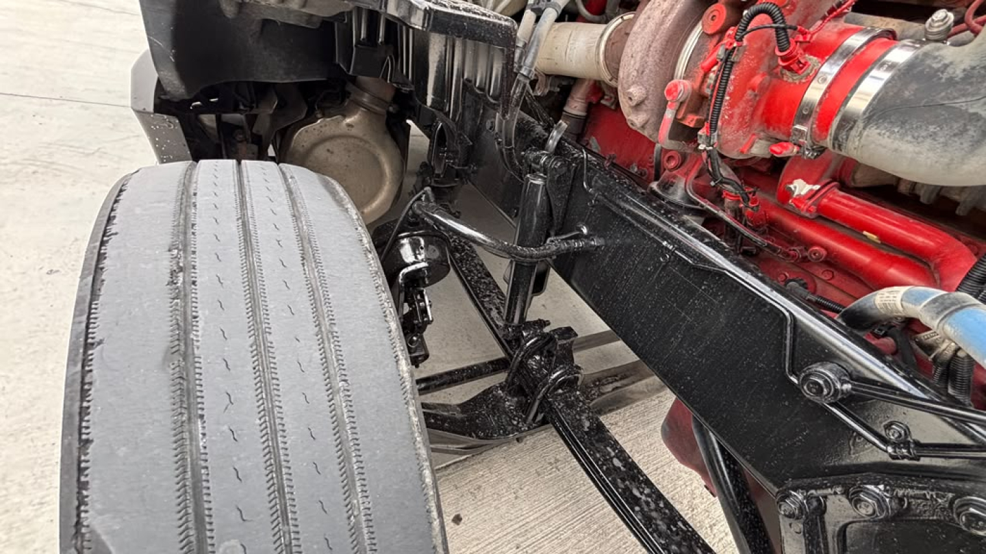 Kenworth T680 chassis with front wheel and engine visible; diesel engine components in red with black frame.
