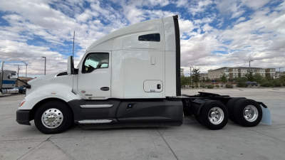 Kenworth T680 2021 conventional sleeper tractor side view showing cab, fuel tanks, and tandem rear axles.