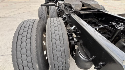 Kenworth T680 chassis with dual rear axles and hexagonal-tread tires visible