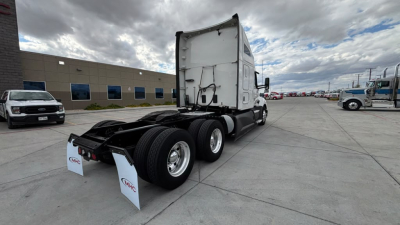 Kenworth T680 tractor cab in view from rear-left showing fifth wheel, dual rear axles, and white mud flaps with MHC logo.