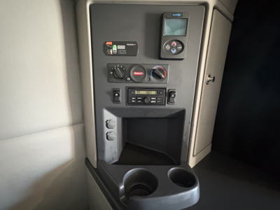 Peterbilt 579 cab interior controls panel and cup holders in view with dashboard switches and radio unit visible.