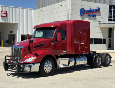 Peterbilt 579 conventional sleeper tractor in red, front view with chrome bumper and grille; stock number B3384P visible at dealership.