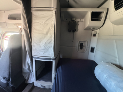Peterbilt 579 truck cab interior showing sleeper compartment with storage cabinet and user controls.