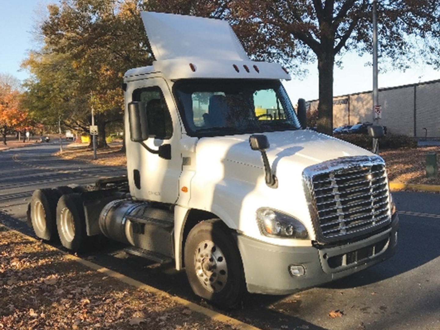 Truck cab of a 2018 Freightliner Cascadia125 conventional daycab with raised sleeper, white exterior, grille, headlights, and dual rear axles.