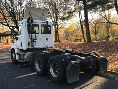 Truck chassis and cab of a 2018 Freightliner Cascadia125 daycab with high-mounted sleeper/hood area, rear dual-axle setup, and exposed fifth wheel area.