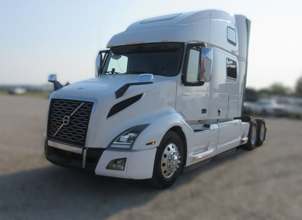 Volvo VNL64T860 sleeper tractor showing front grille, headlights, and side cab detailing with chrome mirrors.