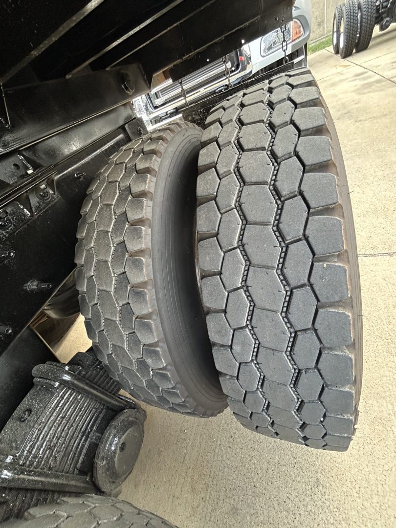 Wheel pair on a Mack GR64F dump truck showing dual rear tires and part of suspension.