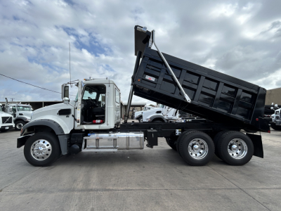 Dump truck with raised dump bed showing Mack GR64F chassis and dual rear axle.