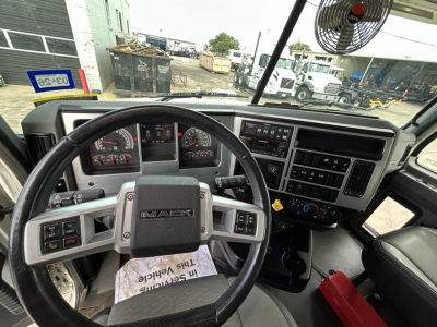 Mack GR64F truck dashboard and steering wheel view showing steering wheel with Mack logo and instrument cluster