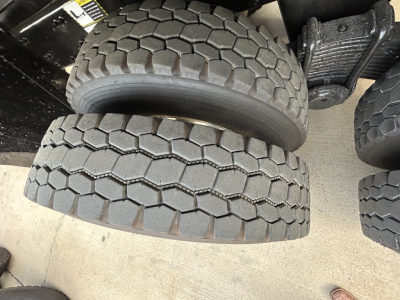 Tire tread pattern close-up on a Mack GR64F dump truck showing dual rear tires and wheel area.