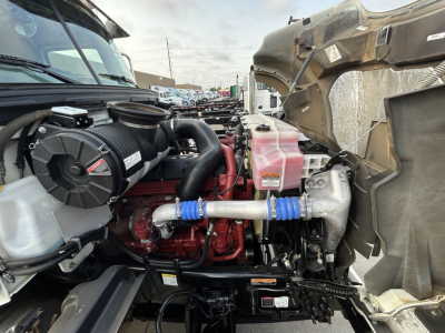 Truck engine bay with turbocharger and intercooler piping visible; coolant reservoir and various hoses labeled.