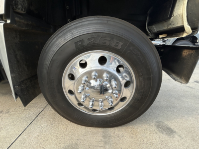 Truck wheel close-up showing tire marked R268 and chrome lug nuts, with hub and part of fender visible