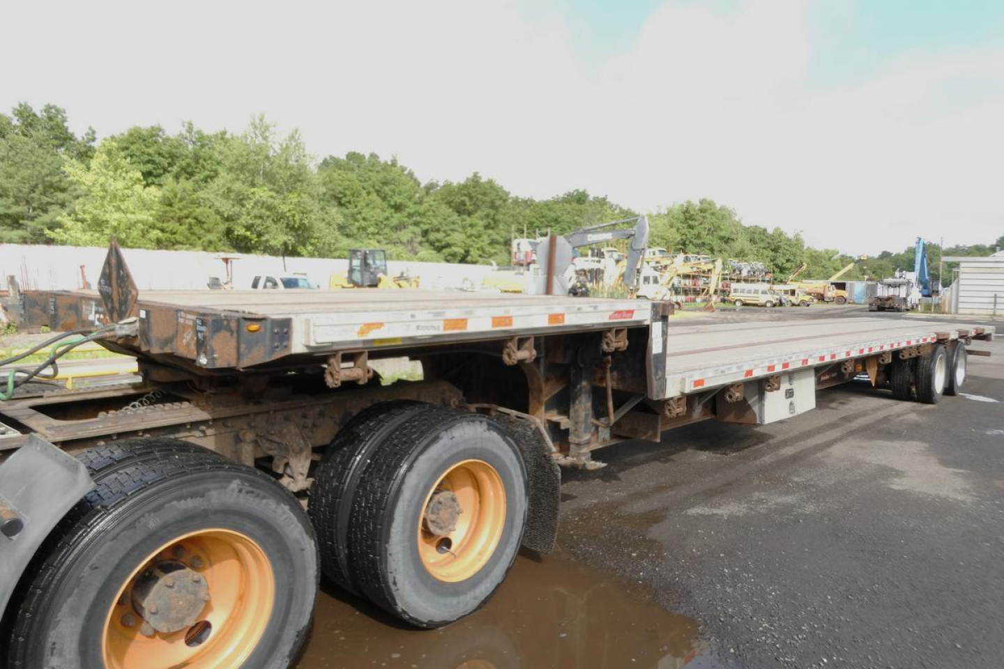 Great Dane low-profile drop deck trailer showing long flatbed with dual rear axles and yellow rims, used condition.