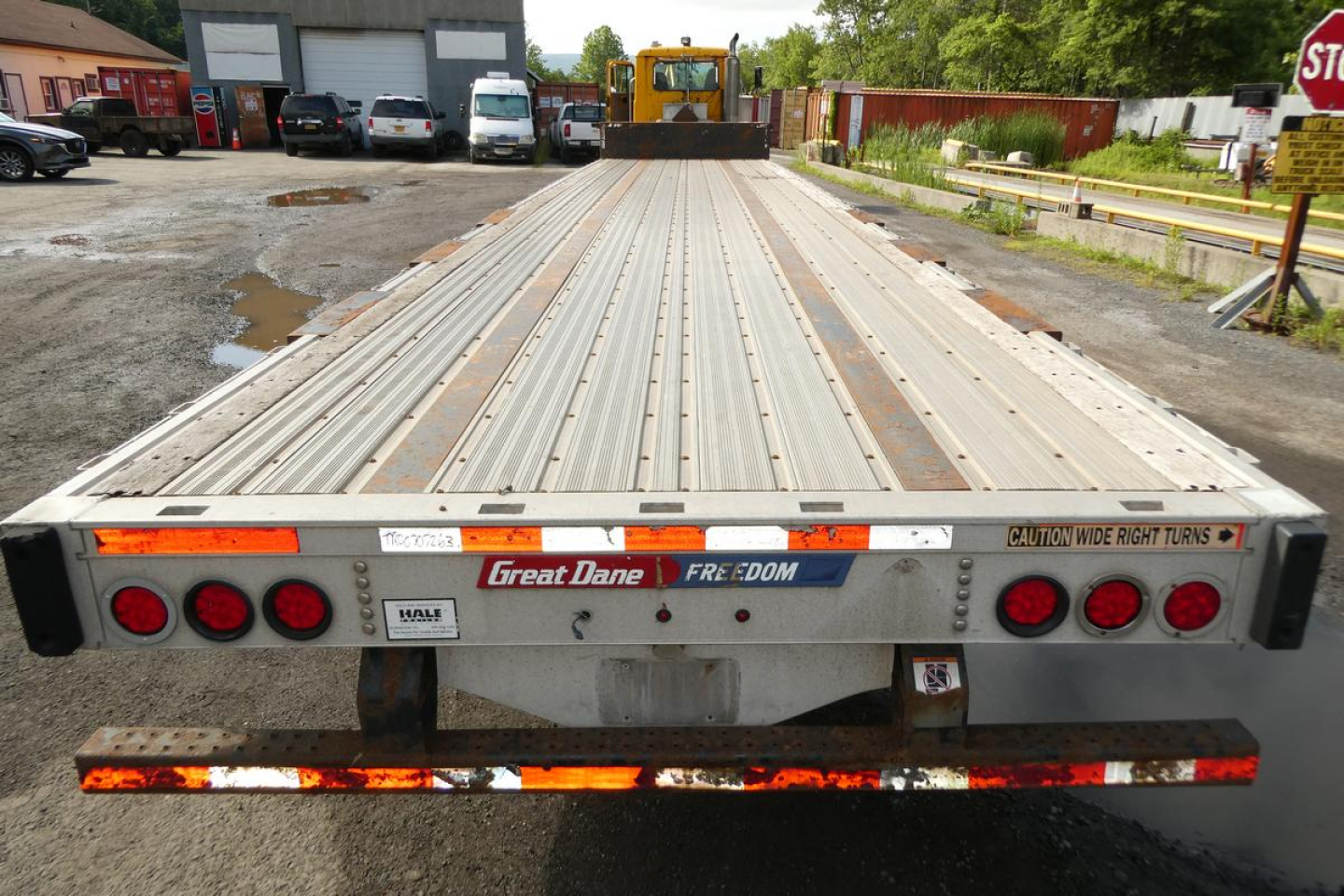 Flatbed trailer rear view showing Great Dane and Freedom decals and taillight clusters.