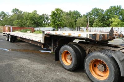 Great Dane FLD002400053 trailer in yard showing dual rear axles with orange rims and long flatbed deck.