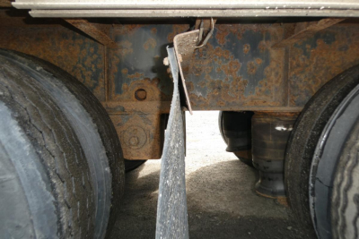 Great Dane trailer undercarriage showing dual wheels and rusted frame with suspension components.