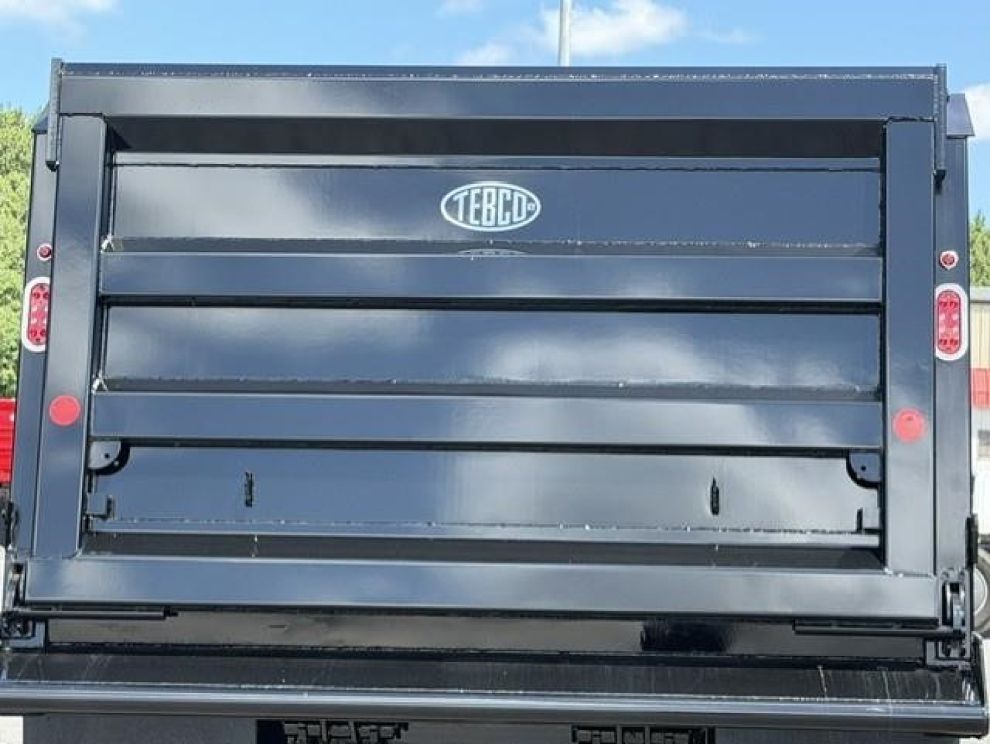 Western Star 47X dump truck bed tailgate showing TEBCO logo and hydraulic components.
